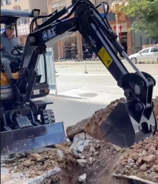Compact excavator digging a narrow trench on an urban street